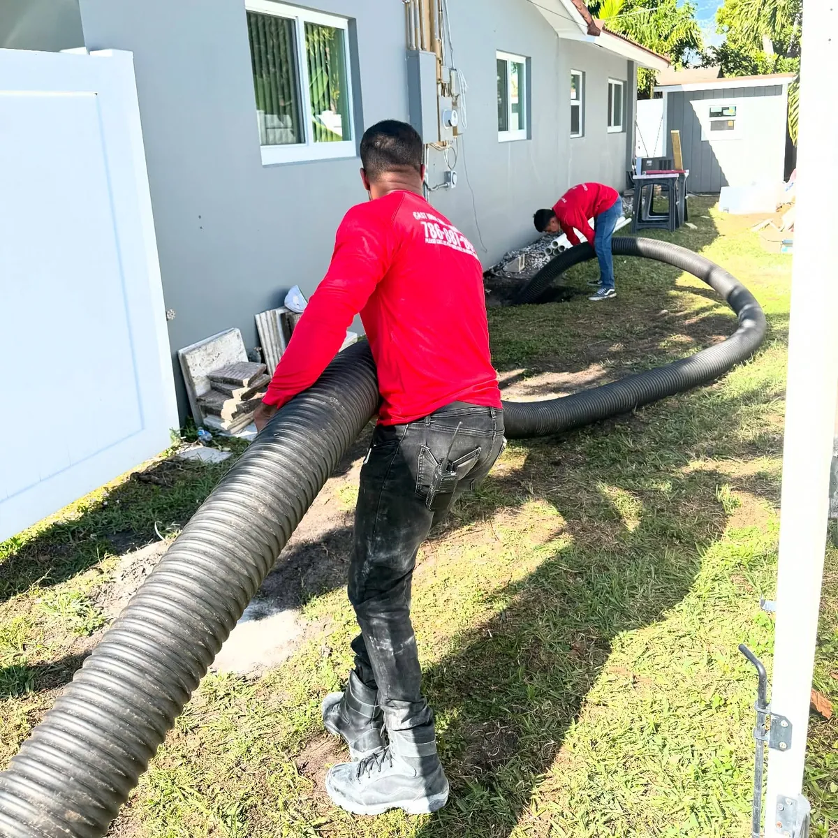 Sewer line repair crew carrying new pipe to replace a sewer line in South Florida